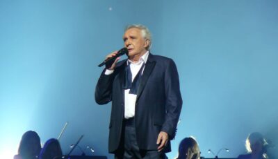 Michel Sardou, chantant les Lacs du Connemara sur scène - Guy Delsaut - cc